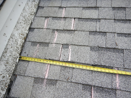 Chalk lines on the roof indicate the breaks in each course of shingles, showing clearly that some of the offsets are less than the required 4-inch minimum, which is set by the shingle manufacturer.